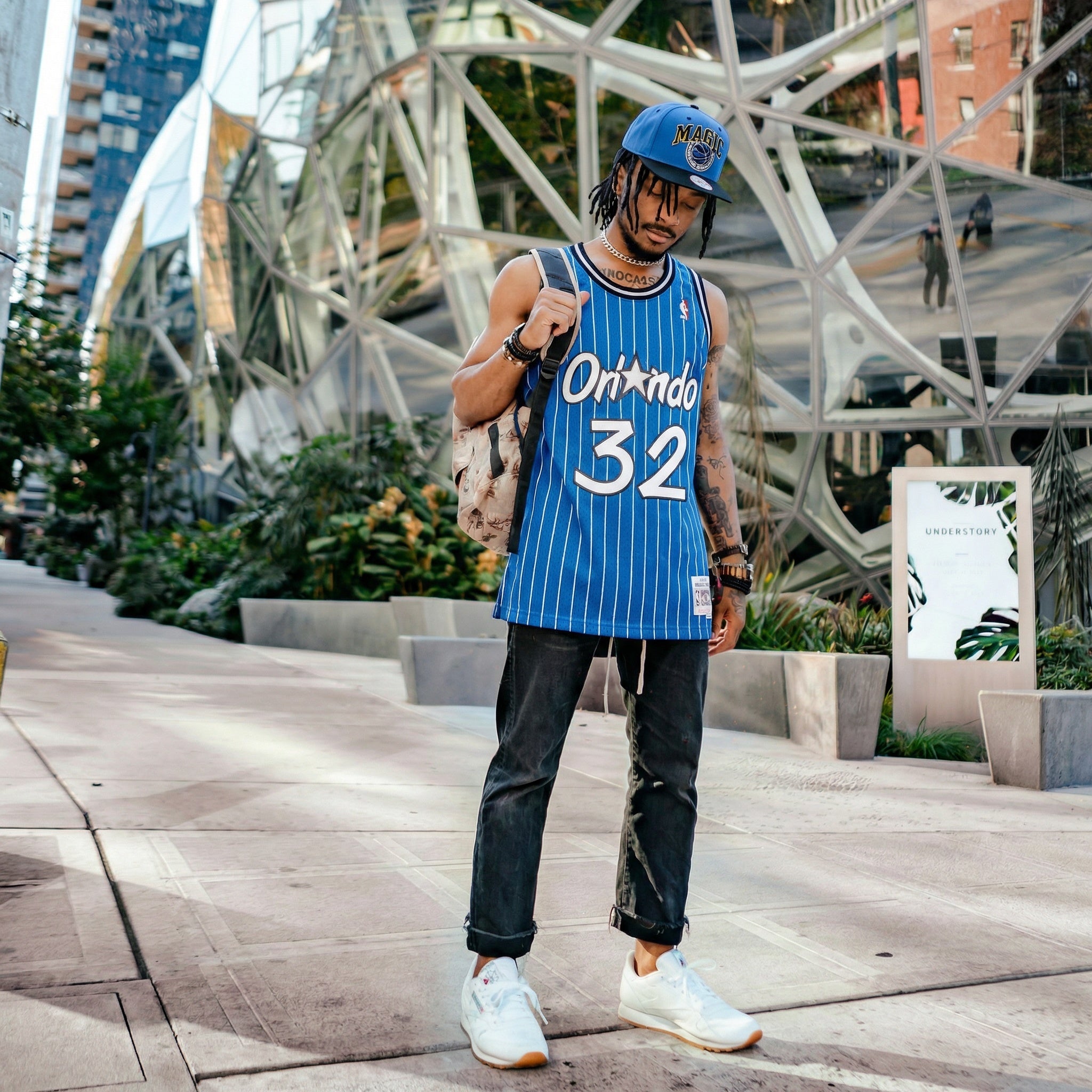 Person wearing an Orlando Magic jersey with the number 32 in an urban setting.